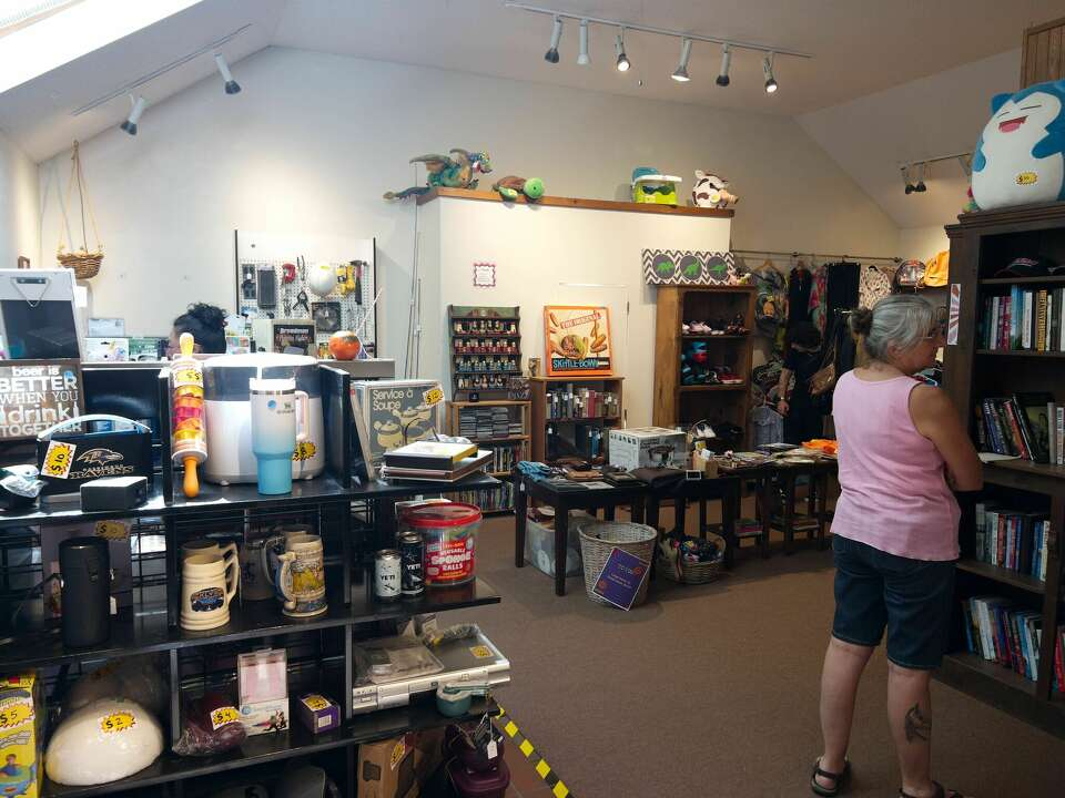 Shoppers browsing a corner of The Funky Flea filled with books, clothing, and collectibles
